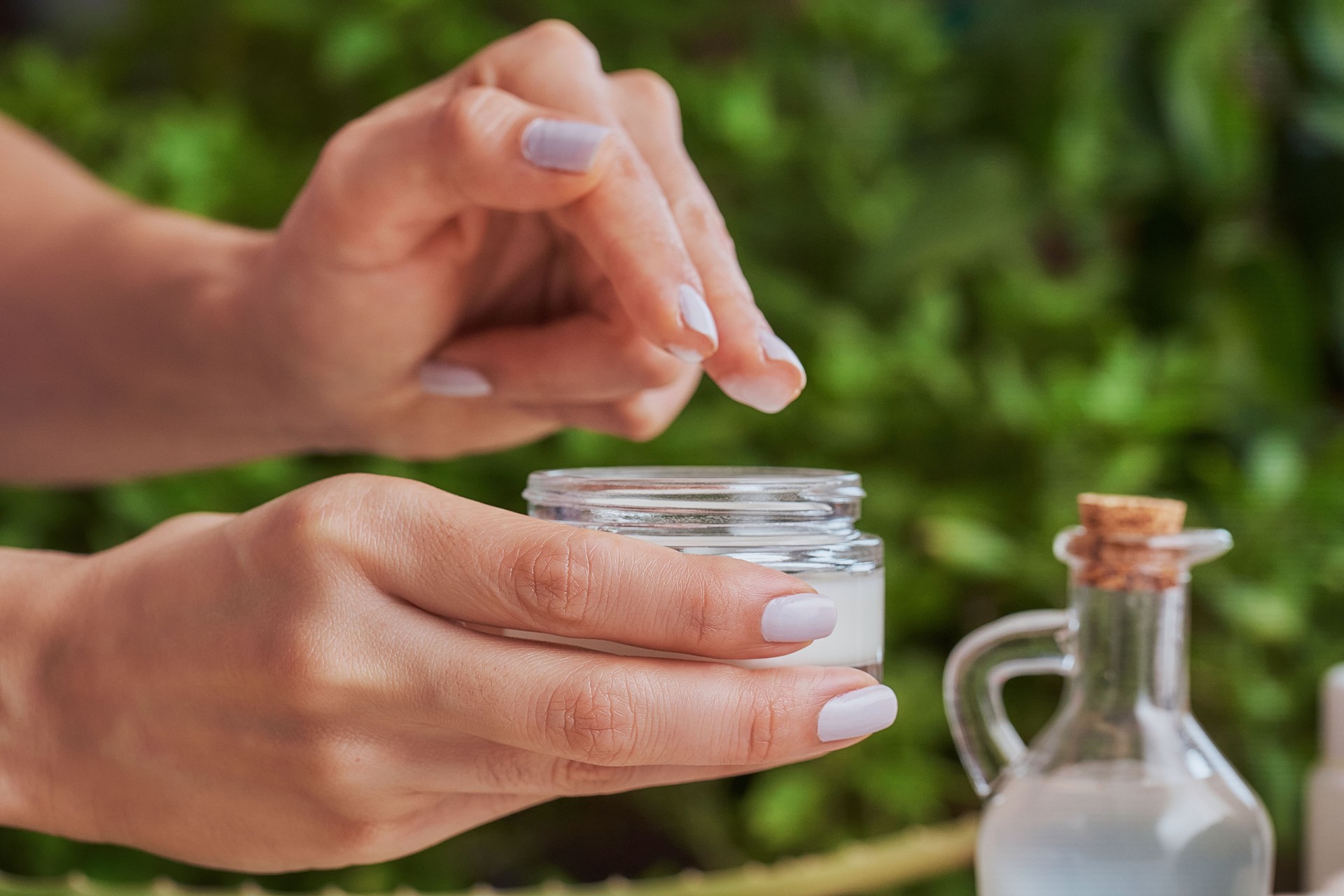 Hispanic young woman moisturizing hands with lotion and aloe vera